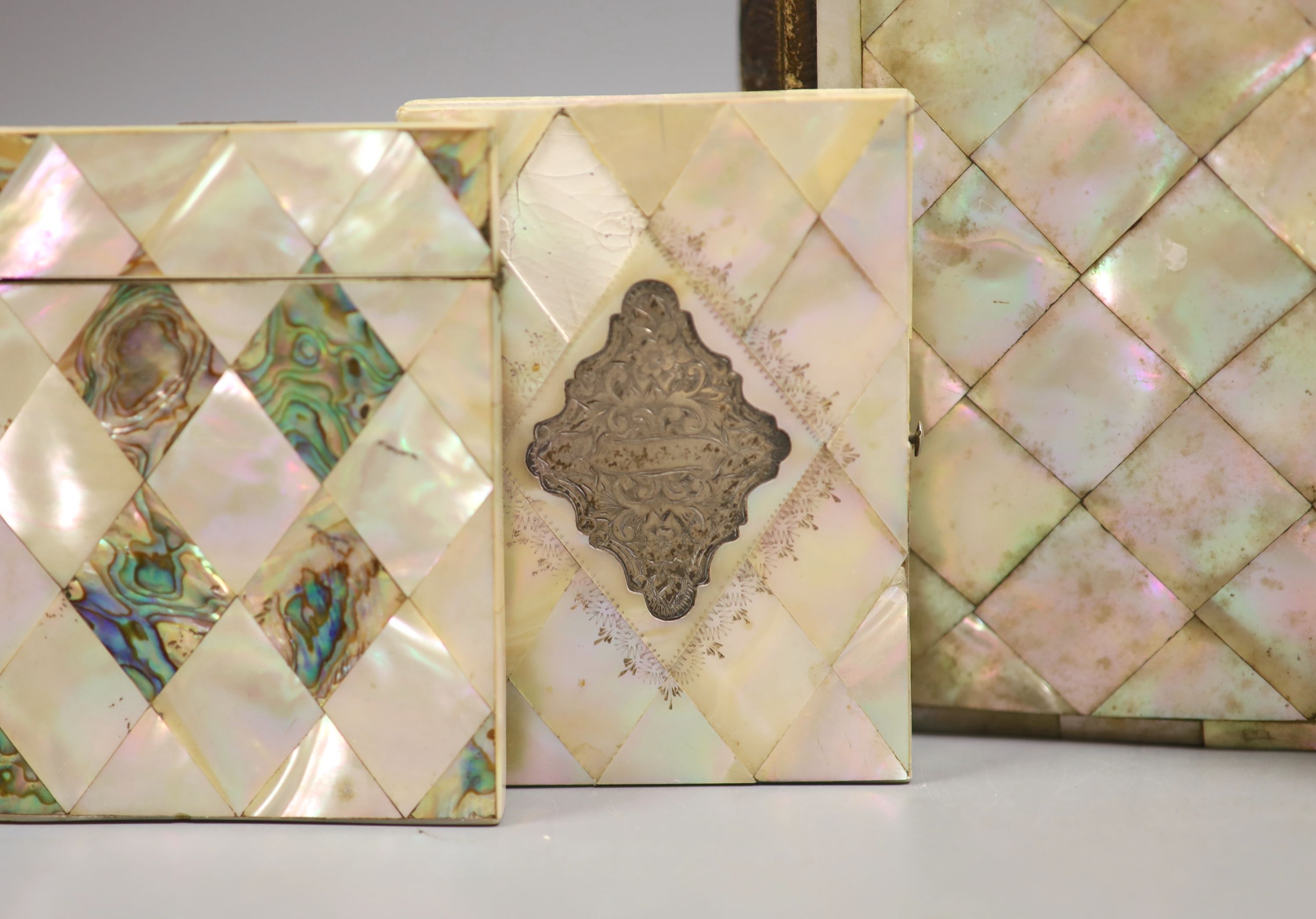 Three Victorian mother of pearl card cases, a papier mache card case and a mother of pearl bound book